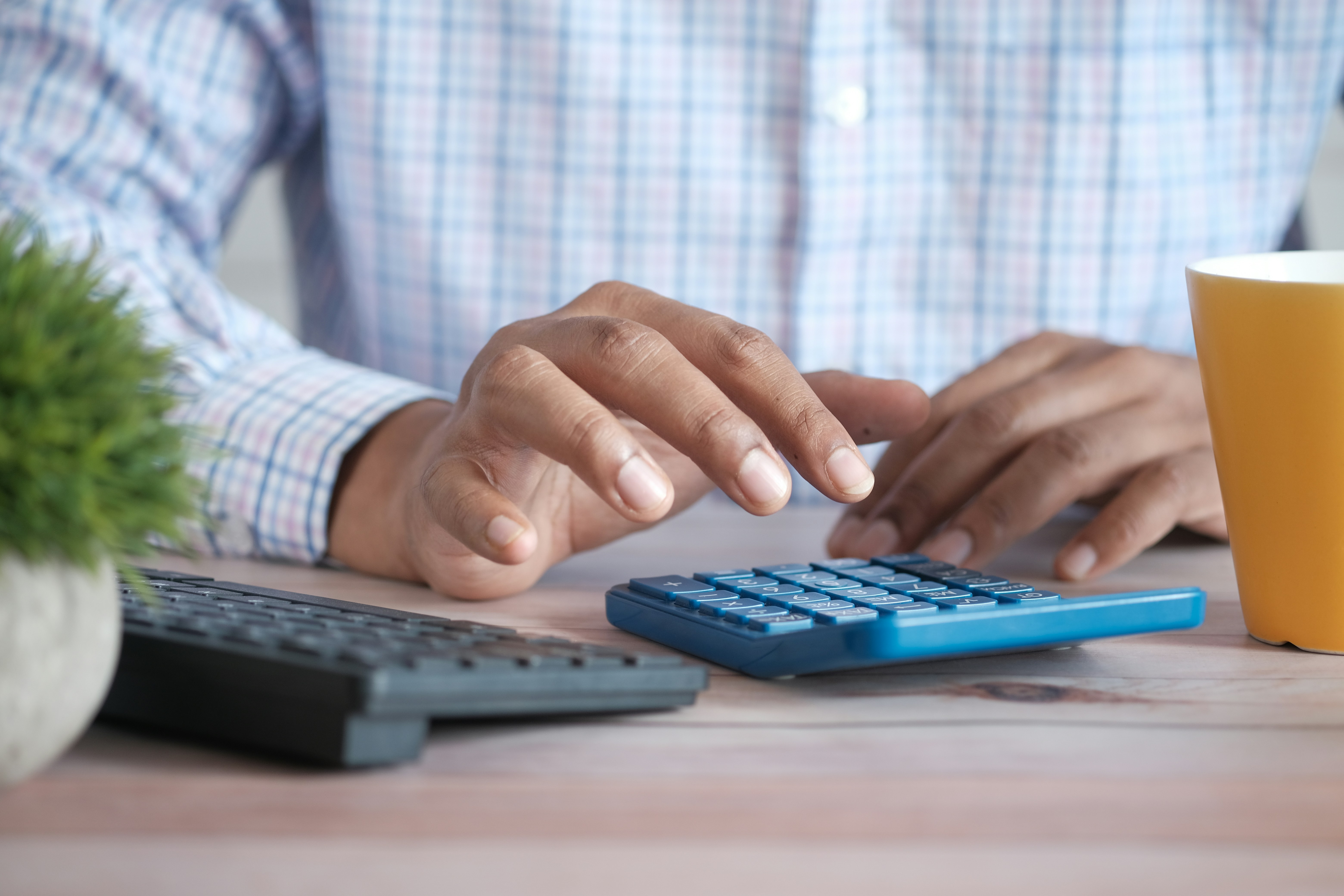 man using a calculator - Basic Bookkeeping for Small Business